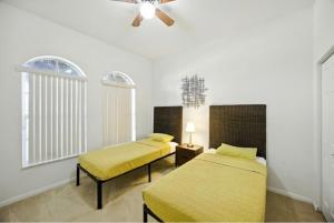 2 Betten in einem Zimmer mit Deckenventilator in der Unterkunft Wellington close to WEF, Polo retreat in Wellington