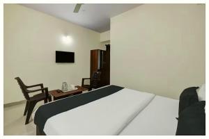 um quarto com uma cama, uma mesa e uma cadeira em Hotel Alekhya Resort Sea Beach em Gopalpur