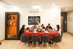 un grupo de personas sentadas alrededor de una mesa en FabHotel La Paz Stay B&B, en Nueva Delhi
