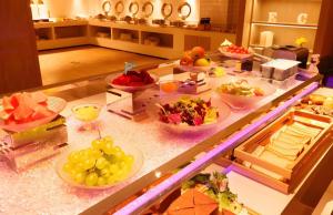 a buffet with many plates of food on a counter at Echarm Hotel Hengshui 2nd High School High-speed Railway Station in Hengshui