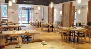 a room with tables and chairs in a building at Vienna Hotel Zhuhai Huafashangdu Nanping Science Industrial Park in Nanping