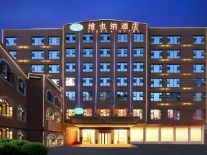 un grand bâtiment avec des lumières sur la façade dans l'établissement Vienna Hotel Guizhou Hezhang, à Hezhang
