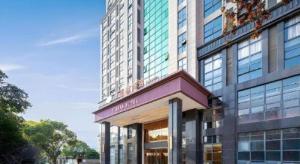 a large tall building with a store in front of it at Vienna Hotel Jiangxi Fengcheng Fnegkuang in Fengcheng