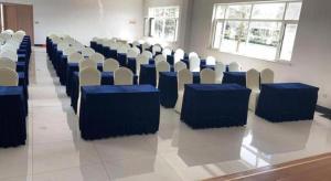 a room with rows of chairs with blue tables at Vienna Hotel Shandong Qingdao Jiaodong International Airport Hai'er Avenue in Madian