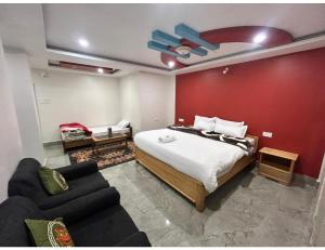 a bedroom with a bed and a living room with a couch at Ana SonamTsomu, Tawang in Tawang
