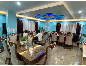 a group of people sitting around a table in a restaurant at Ana SonamTsomu, Tawang in Tawang
