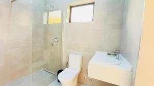 a bathroom with a toilet and a sink and a shower at Kulala Stays Lodge in Livingstone