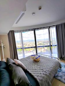 JTower Residences beside SM Jmall Mandaue في مانداوي سيتي: غرفة نوم بسرير ونوافذ كبيرة مطلة
