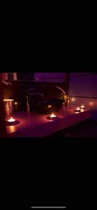 a table with lit candles on it in the dark at La Gold Room jacuzzi et sauna in Perpignan +9 photos