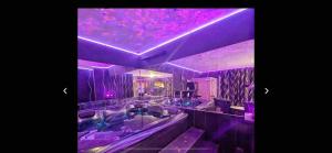 a purple room with a bath tub and a purple ceiling at La Gold Room jacuzzi et sauna in Perpignan