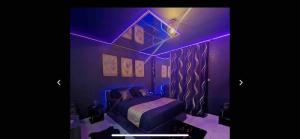 a purple bedroom with a bed with a purple lighting at La Gold Room jacuzzi et sauna in Perpignan