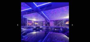 a bathroom with a tub with purple lights in it at La Gold Room jacuzzi et sauna in Perpignan
