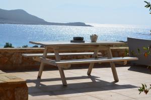 a picnic table on a patio overlooking the water at Villa Aristoteles in Halki