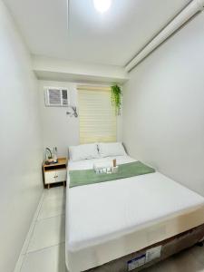 a white bedroom with a large bed in it at 2BR Family Condo for 6pax near IT Park Budget Stay at Urban Deca Homes Banilad by Gerra unit Nathan in Mandaue City