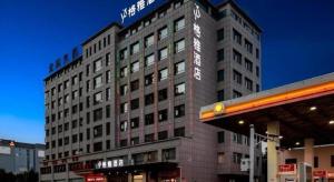 un grand bâtiment avec une enseigne au sommet dans l'établissement GYA Hotel Taiyuan Zonggai Zone Ancient County Chengnan Station, à Taiyuan