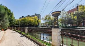 un pont sur une rivière avec un poteau sur cette rivière dans l'établissement GELI Kunming North Railway Station Zoo, à Kunming