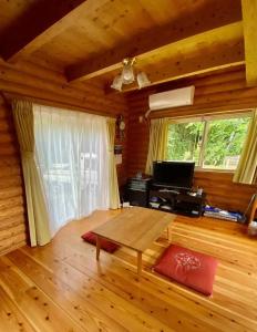 a living room with a wooden floor and a table at コテージ杏庵 Cottage Anzuan in Minamioguni +8 photos