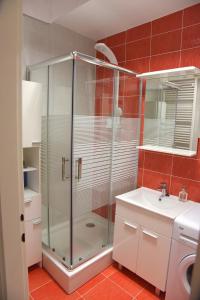 a bathroom with a glass shower and a sink at Apartmani Vedmar in Zagreb