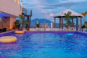 een zwembad met een prieel en een resort bij Kandi Heaven in White Tower in Angeles