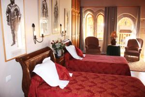 een hotelkamer met 2 bedden en 2 stoelen bij L'Ancienne Auberge in Puycelci