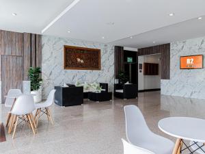 a lobby with white chairs and tables and a couch at B2 Lampang Boutique & Budget Hotel in Ban Nam Thong
