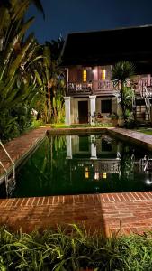 a swimming pool in front of a house at Villa Maydou Boutique Hotel in Luang Prabang