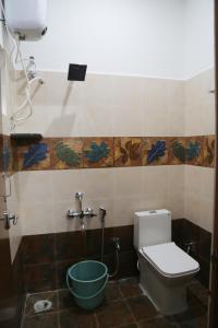 a bathroom with a toilet and a bucket at Go COOL-IN in Yercaud