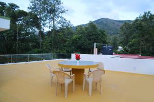 a table and chairs on the roof of a house at Go COOL-IN in Yercaud