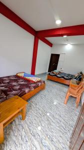 a room with two beds and a table and chairs at Vista Valley View homestay in Dirang Dzong +1 photo