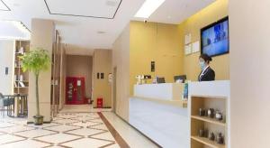 a woman wearing a mask in a hospital lobby at City Comfort Inn Jiujiang Gongqing Science and Technology College High-speed Railway Station in Gongqingcheng