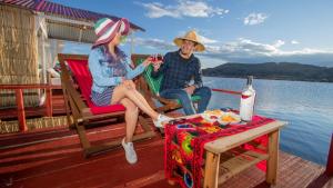a man and woman sitting on the deck of a boat at Sol del Titikaka Lodge in Puno +9 photos