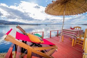 a wooden deck with a table and an umbrella at Sol del Titikaka Lodge in Puno