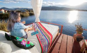 a young girl sitting on a boat on the water at Sol del Titikaka Lodge in Puno +11 photos