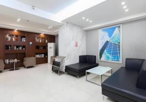 a waiting room with a chair and a couch and a window at City Comfort Inn Wuhan Jiefang Avenue Xinrong Light Rail Station in Wuhan