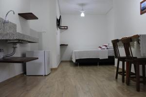 Una cocina con nevera y una cama en una habitación. en Hotel Reobot Center, en Garanhuns