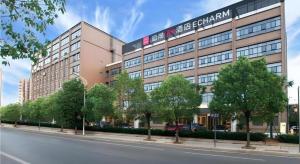 a large building on the side of a street at Echarm Plus Hotel Wuhan Wenhua Boulevard Dahualing Subway Statiom in Wuhan