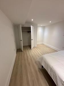 une chambre vide avec un lit et un placard dans l'établissement Luxury, Brand-new, Specious, 2-Bedroom Apartment, à Colline De Richmond