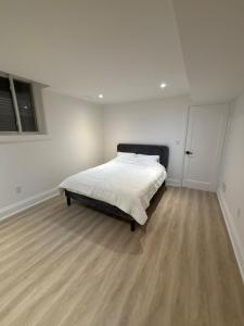 une chambre avec un lit dans une pièce blanche dans l'établissement Luxury, Brand-new, Specious, 2-Bedroom Apartment, à Colline De Richmond