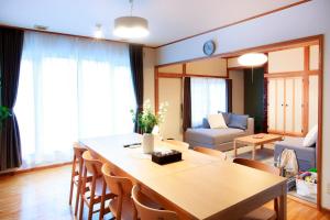 een woonkamer met een tafel en een bank bij KazeVillaFurano in Furano