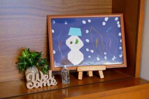 een foto van een sneeuwpop op een plank bij KazeVillaFurano in Furano