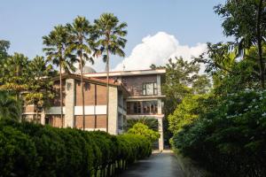 a house with palm trees in front of it at Simala Retreat Baiguney in Naya Bāzār