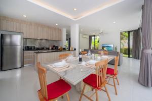 a kitchen and dining room with a table and chairs at Luxury 5BR Pool Villa near Beach and Golf - Laguna Park 2 in Ban Phru Champa