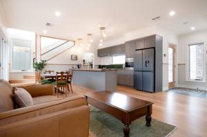 a living room and kitchen with a couch and a table at 2 Houses, 1 Booking, Great Location in Launceston