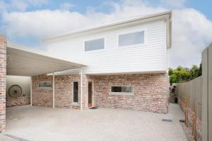 a white house with a brick wall at 2 Houses, 1 Booking, Great Location in Launceston