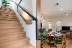 a dining room and kitchen with a staircase and a dining table at 2 Houses, 1 Booking, Great Location in Launceston