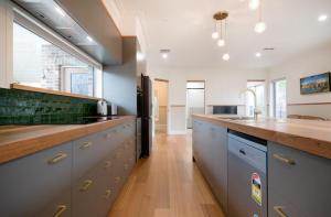 a large kitchen with a wooden counter top and a sink at 2 Houses, 1 Booking, Great Location in Launceston +10 photos