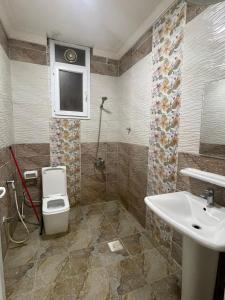 ein Badezimmer mit Toilette und Waschbecken in der Unterkunft الحى التجارى RED-13 ALhaddad in Salalah + 4 Fotos