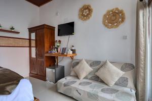 ein Wohnzimmer mit Sofa und Fernseher in der Unterkunft Rostin Mesari Villa in Nusa Penida