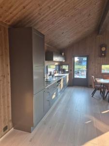 a kitchen with wooden floors and a wooden ceiling at Modern mountain cabin with panorama view in Eggedal