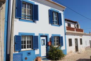 Un bâtiment bleu et blanc avec volets bleus dans l'établissement Casa dos Coelhos, à Barão de São João